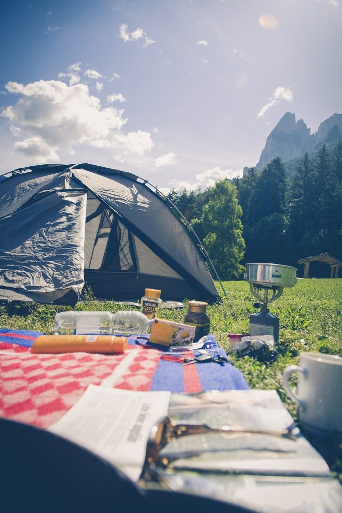 a tent set up next to a picnic blanket
